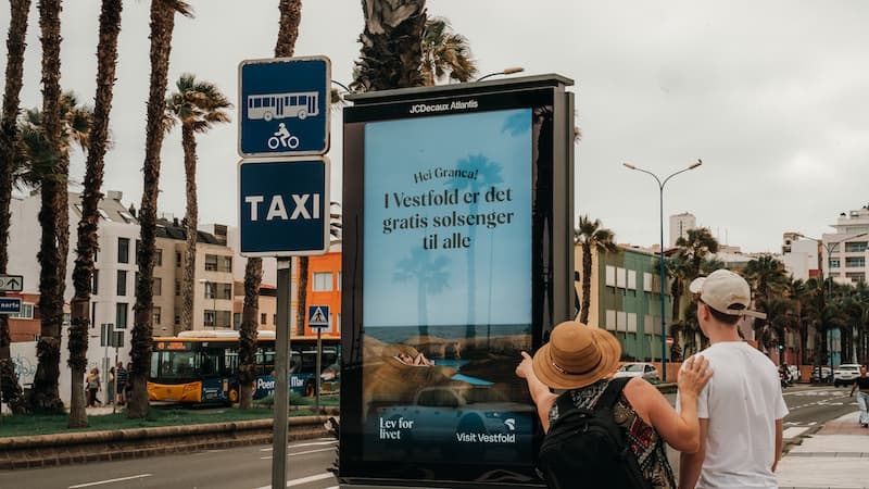 mor og sønn perker på en utendørsannonse fra visit vestfold