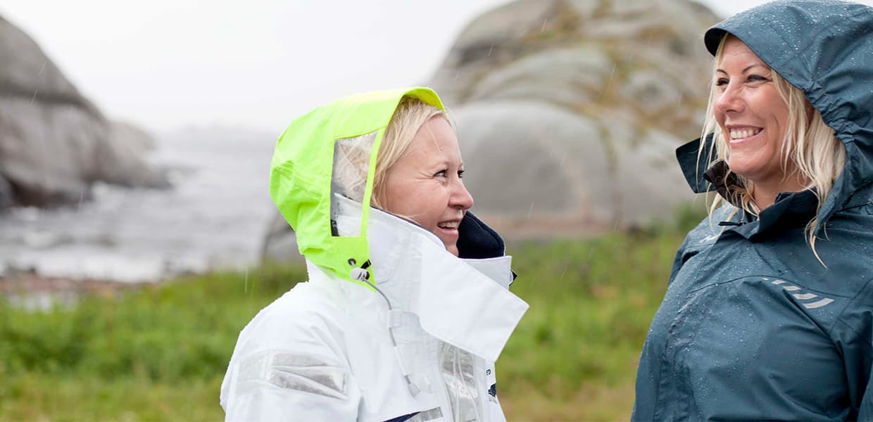 to personer i regntøy på tur ved kysten