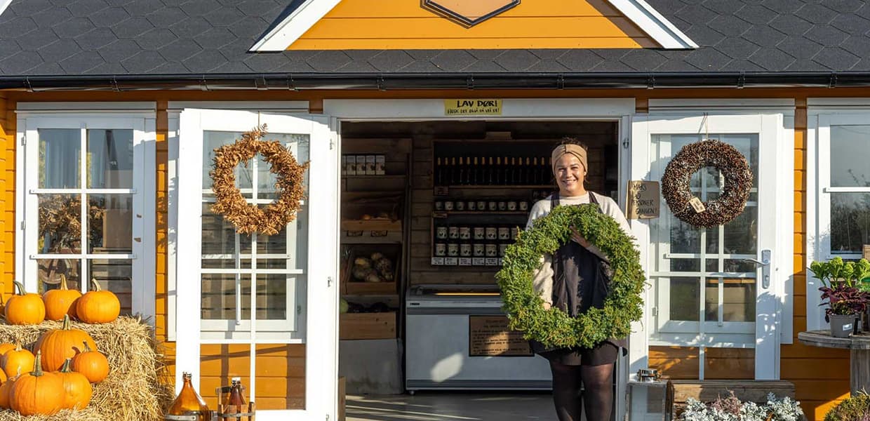 Dame holder krans i gårdsbutikk