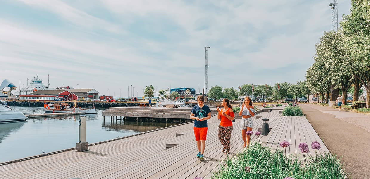 tre personer går langs brygga i Horten