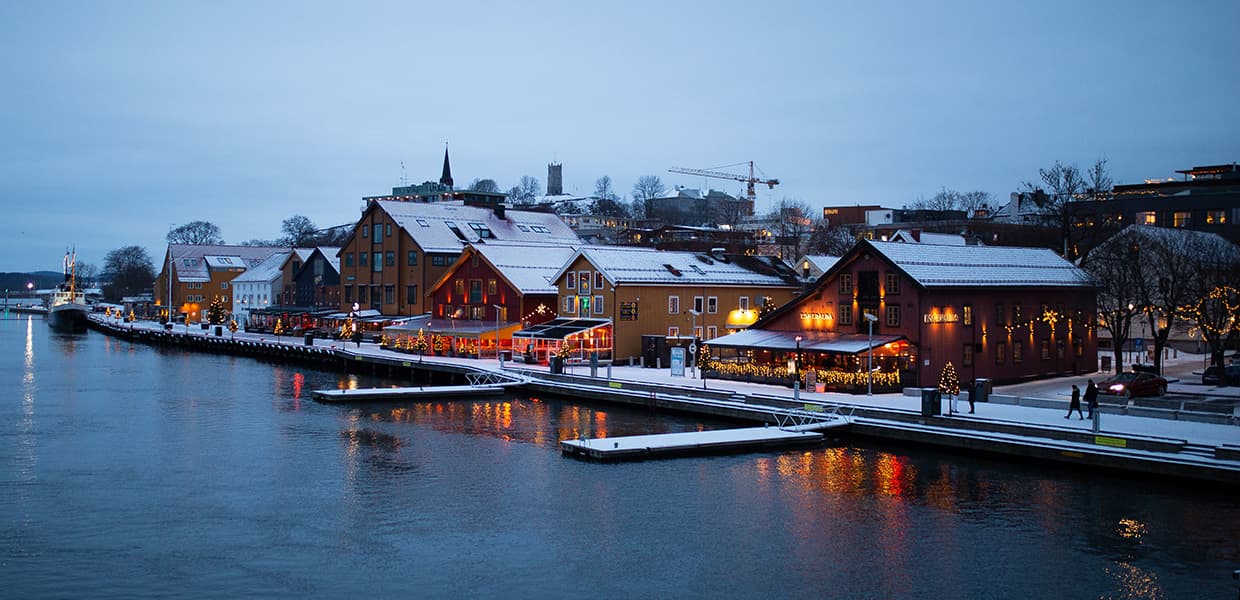 brygga i Tønsberg på vinteren med julelys pyntet på bygninger.