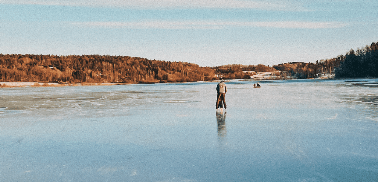 person på skøyte med barn på islagt sjø